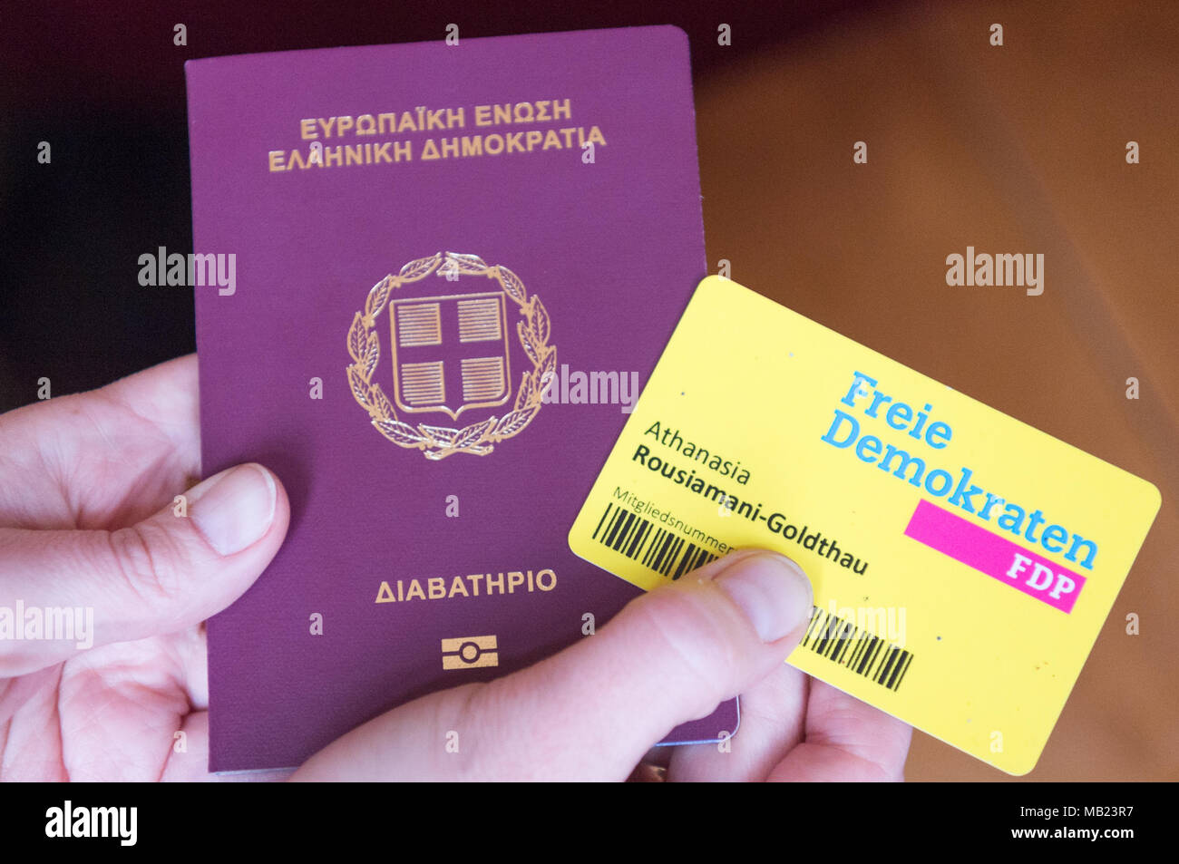 20 March 2018, Germany, Berlin: Athanasia Rousiamani-Goldthau of the Free Democratic Party (FDP), a politican from Greece, holds up her Greek passport and her FDP member's card. She joined the German FDP in her youth despite only having a Greek passport. Photo: Christophe Gateau/dpa Stock Photo