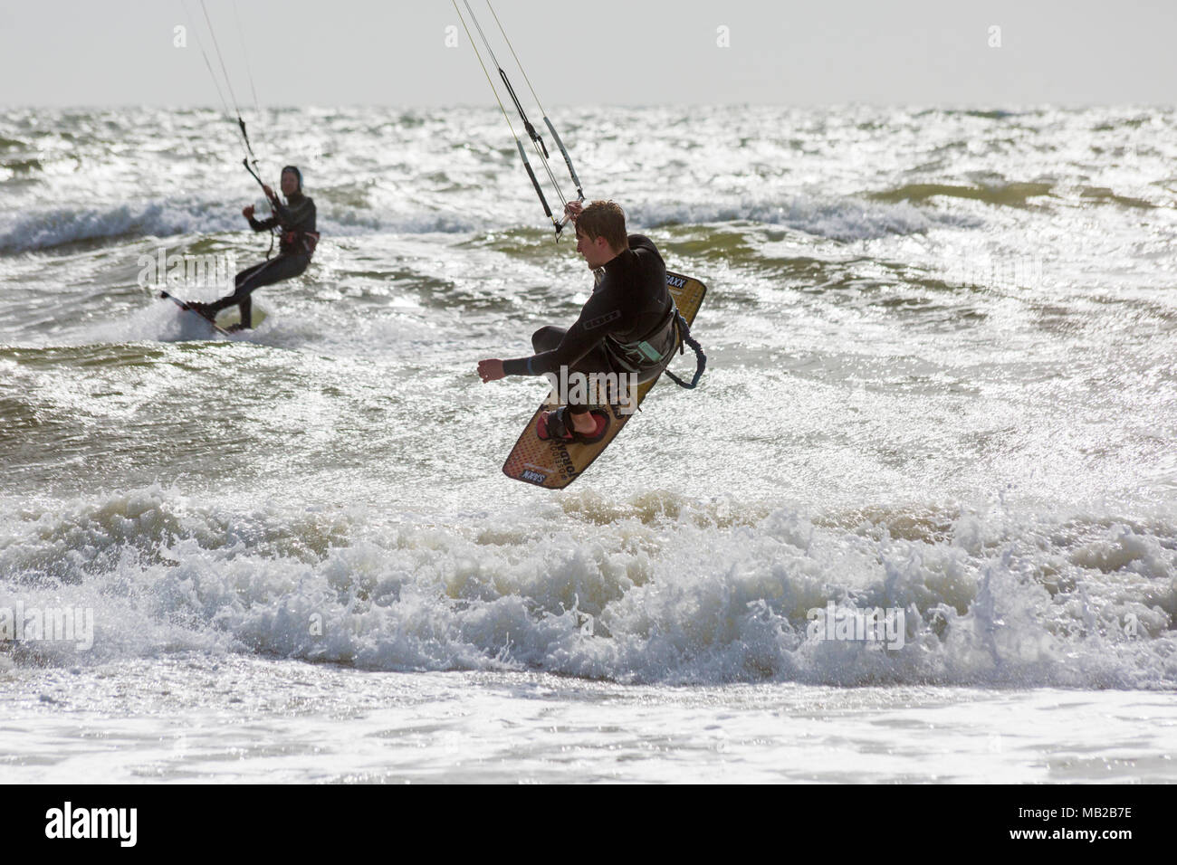 Sandbanks, Poole, Dorset, UK. 6th April, 2018. UK weather: breezy day at Sandbanks as kite surfers make the most of the windy conditions to get high in the air, airborne. kitesurfers kite surfers kite surfer kiteboarders kite boarders kitesurfer kitesurfing kite surfing kiteboarding kite boarding kiteboarder kite boarder Stock Photo