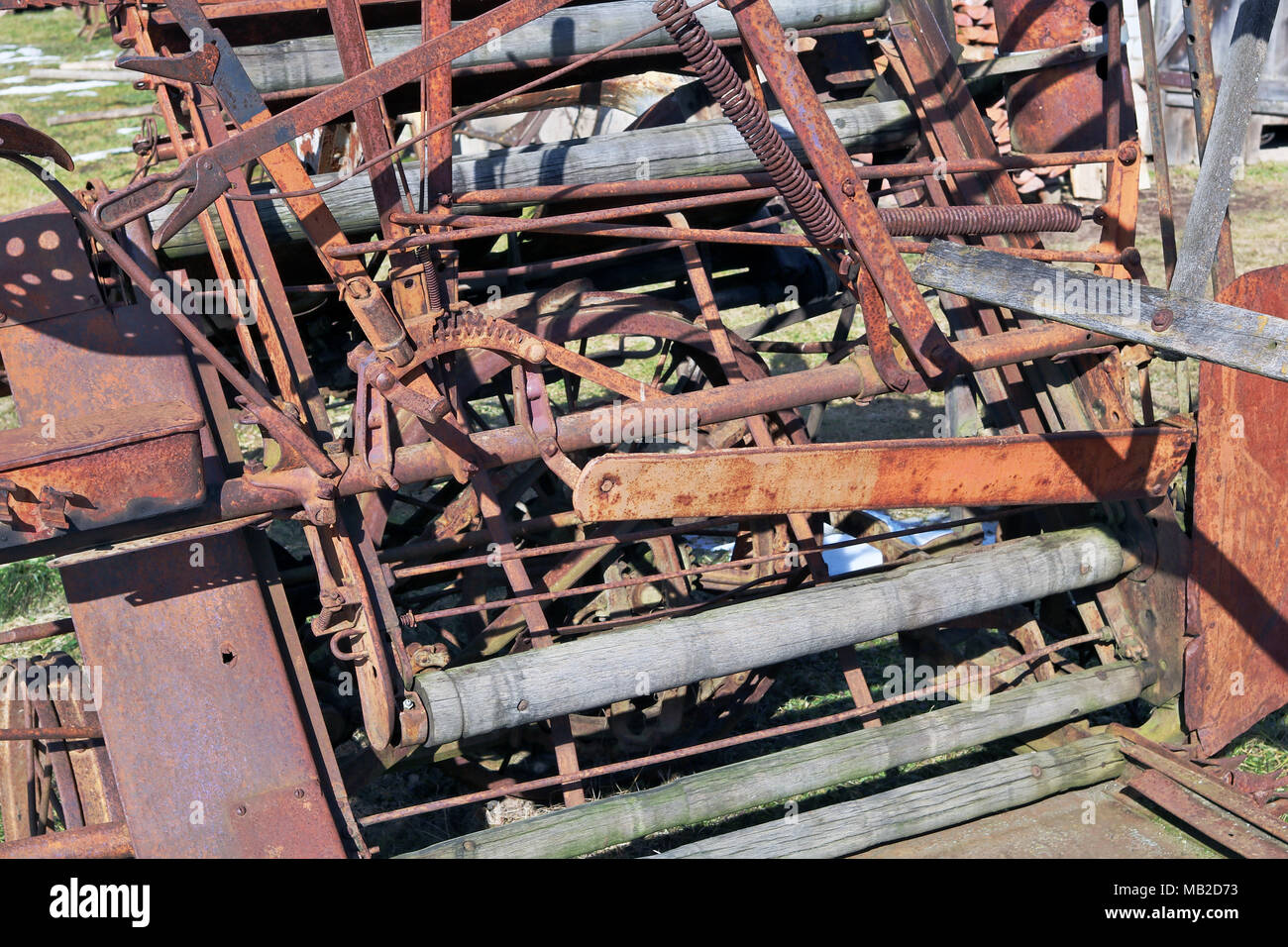 Abstract background from chaos and weaving of rusty metal parts of vintage agricultural machinery. Sunny day outdoor shot Stock Photo