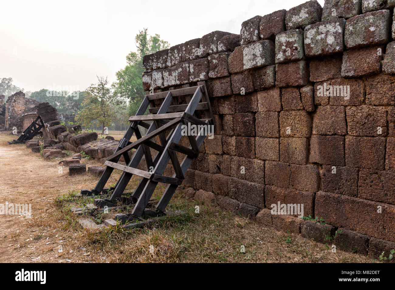 Construction of stone wall was braced by wooden of Ancient Khmer architecture. Siem Reap, Cambodia. Stock Photo