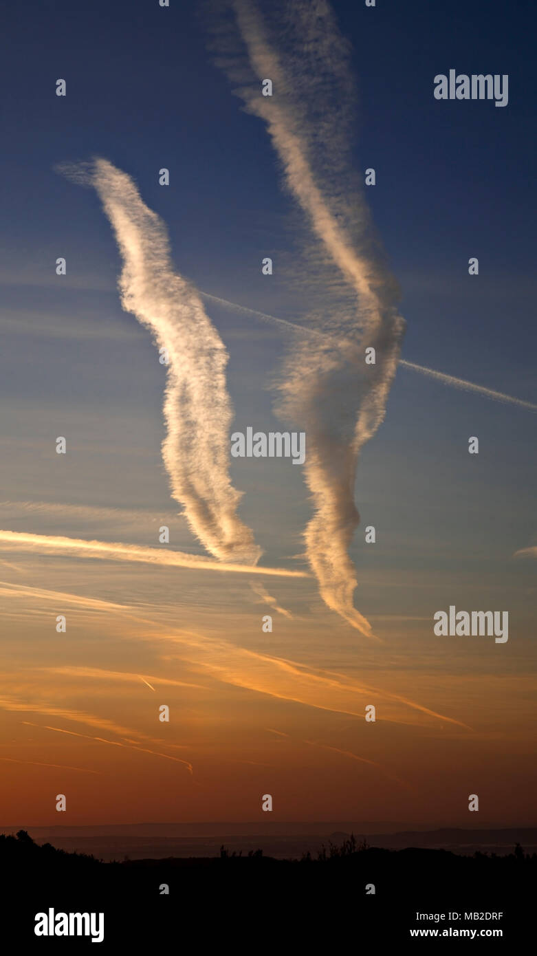 Aircraft contrails in the sky over North Wales at dawn Stock Photo