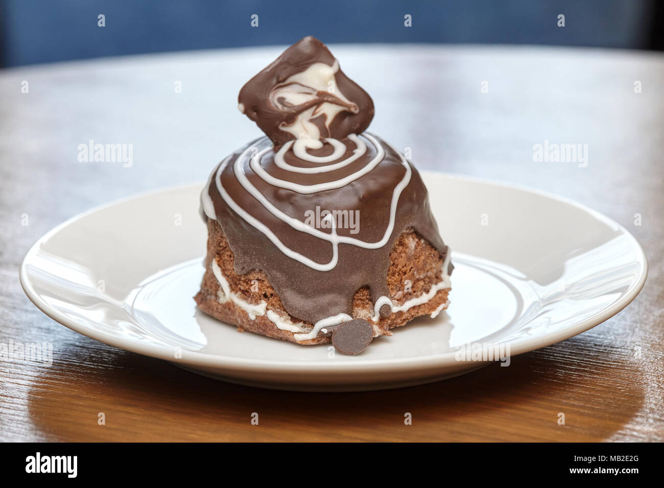 Chocolate pastry covered with glaze on wooden table Stock Photo
