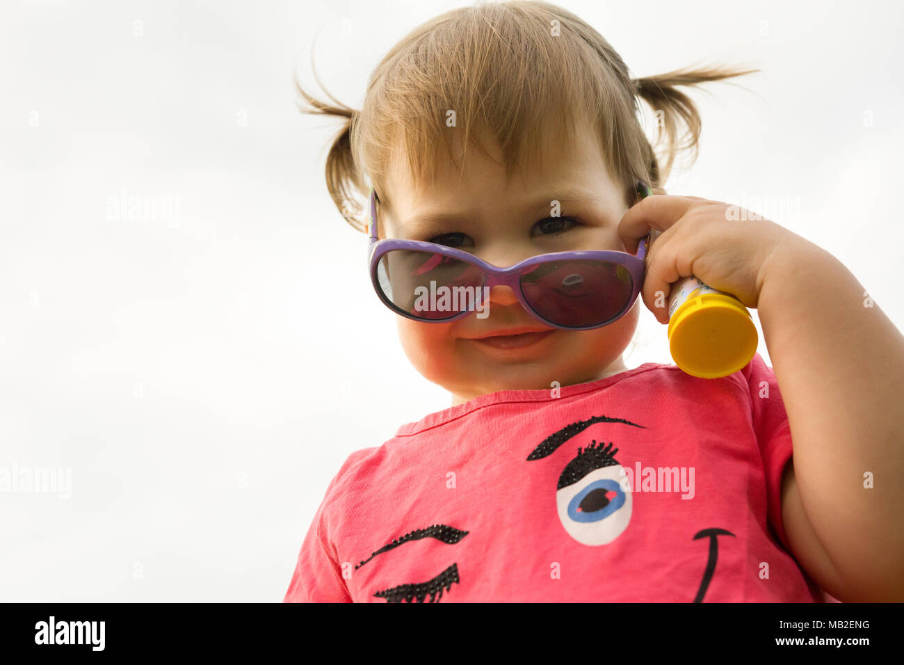Little hild girl playing in park in front of green grass Stock Photo