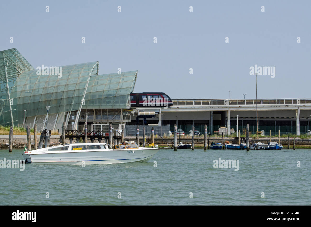 VENICE, ITALY - JUNE 13, 2017: The shuttle train leaving the station which takes passengers from cruise ships over a canal and into the historic city  Stock Photo