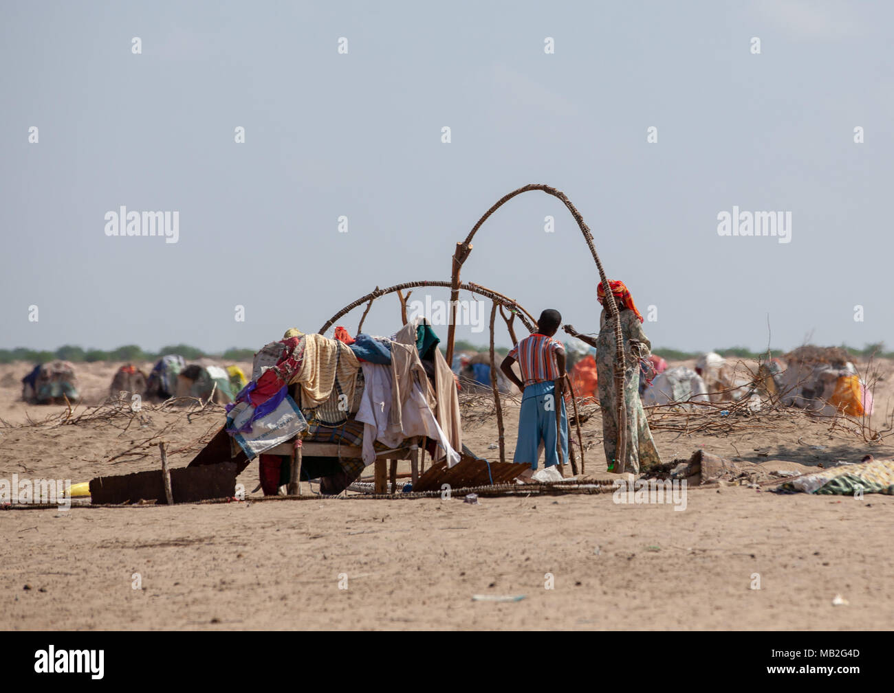 Family building a somali hut called aqal in the desert, Awdal region, Lughaya, Somaliland Stock Photo