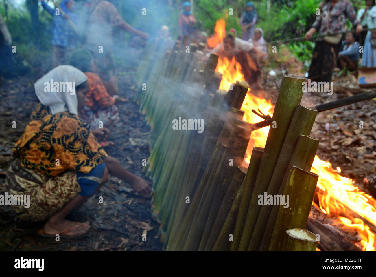 Meratus Dayak women make traditional food from sticky rice and cooked with bamboo then burned, the food is called Lamang. Traditional food from borneo. Stock Photo