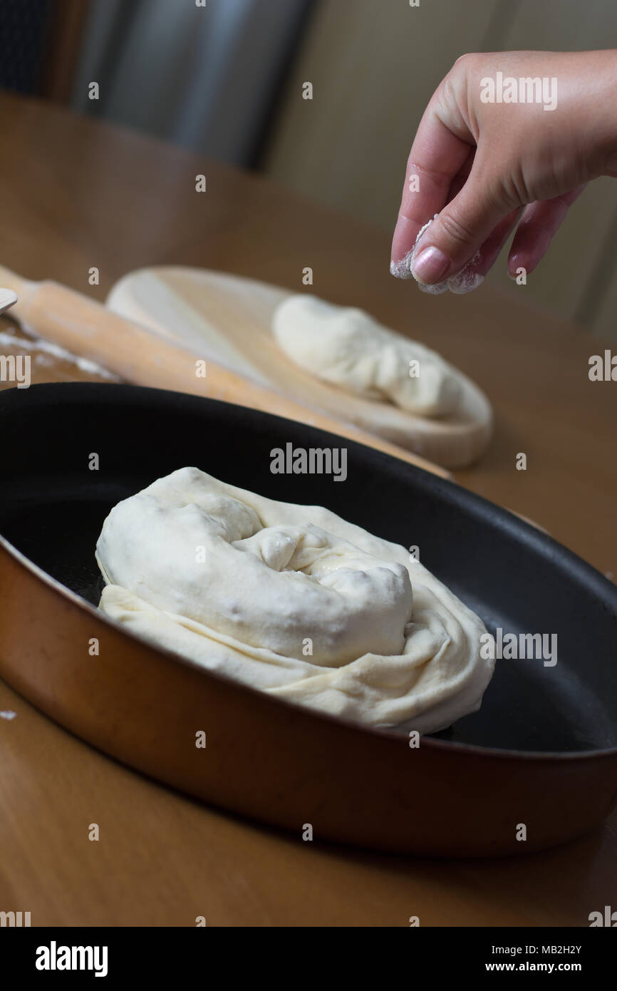 Woman making dough with meat at home on the kitchen table Stock Photo