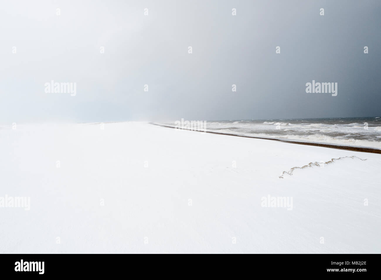 Snow covered beach looking west towards Blakeney Point from Cley North Norfolk February Stock Photo