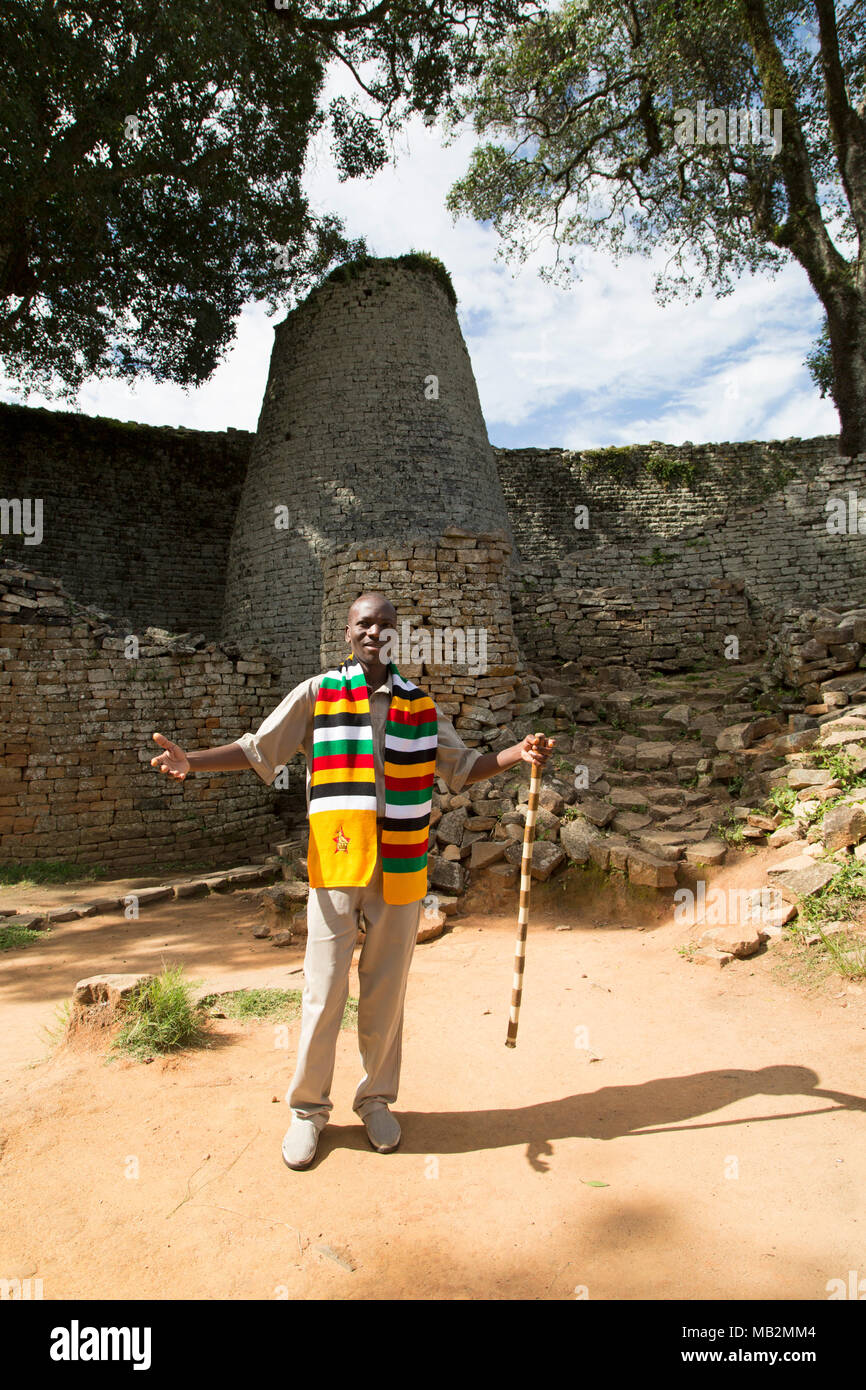 Lovemore, a guide at Great Zimbabwe near Masvingo in Zimbabwe. He explains about the stonework buildings that were the capital of the Kingdom of Zimba Stock Photo