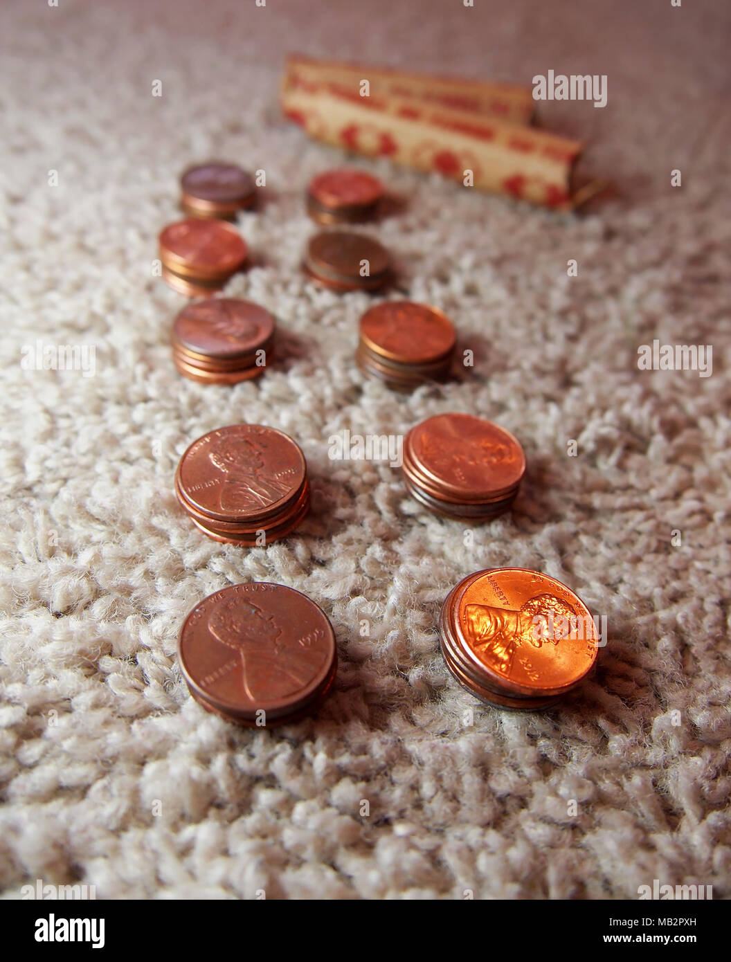 Stacks of copper American pennies are lined up on a carpet in preparation to be packed into paper rolls of 50. Stock Photo