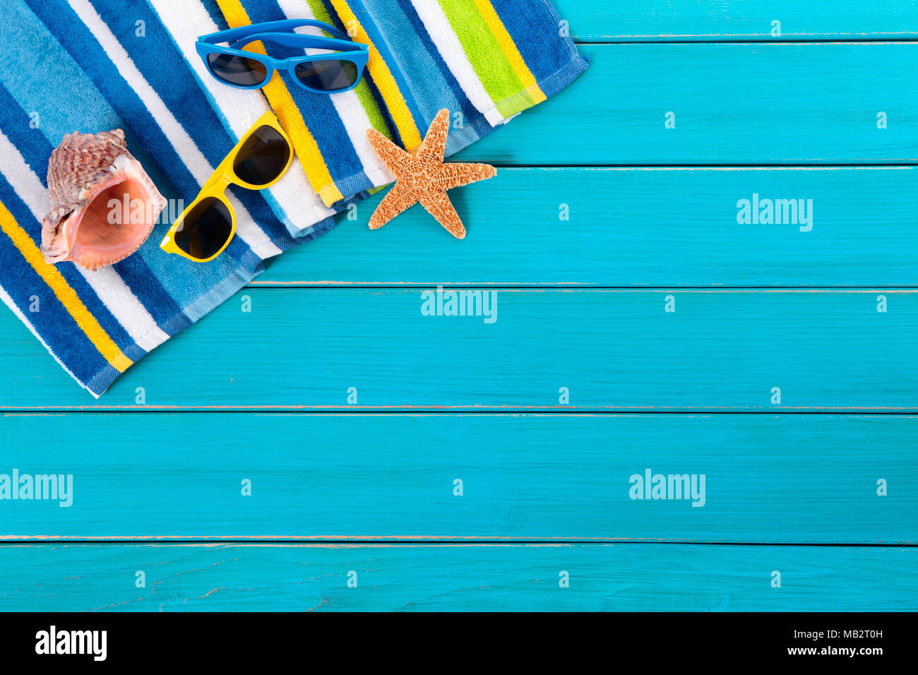 https://c8.alamy.com/comp/MB2T0H/beach-scene-with-striped-towel-sunglasses-starfish-and-seashell-on-old-weathered-blue-painted-wood-decking-space-for-copy-MB2T0H.jpg