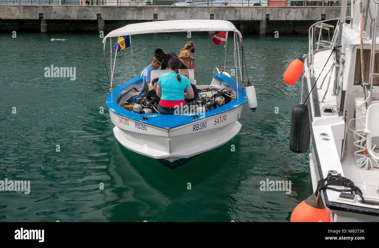 Small diving boat with divers and equipment is leaving for the trip to dive sites. Bridgetown, Barbados. Stock Photo