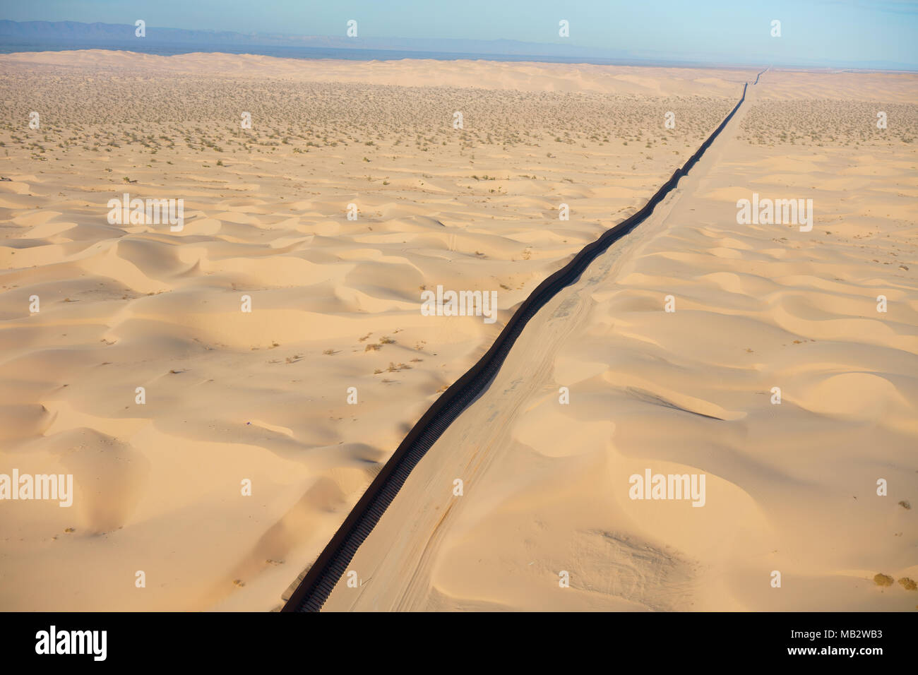 AERIAL VIEW. International border between Mexico (left of wall) and the United States. Algodones Dunes, Sonoran Desert, Baja California, Mexico. Stock Photo