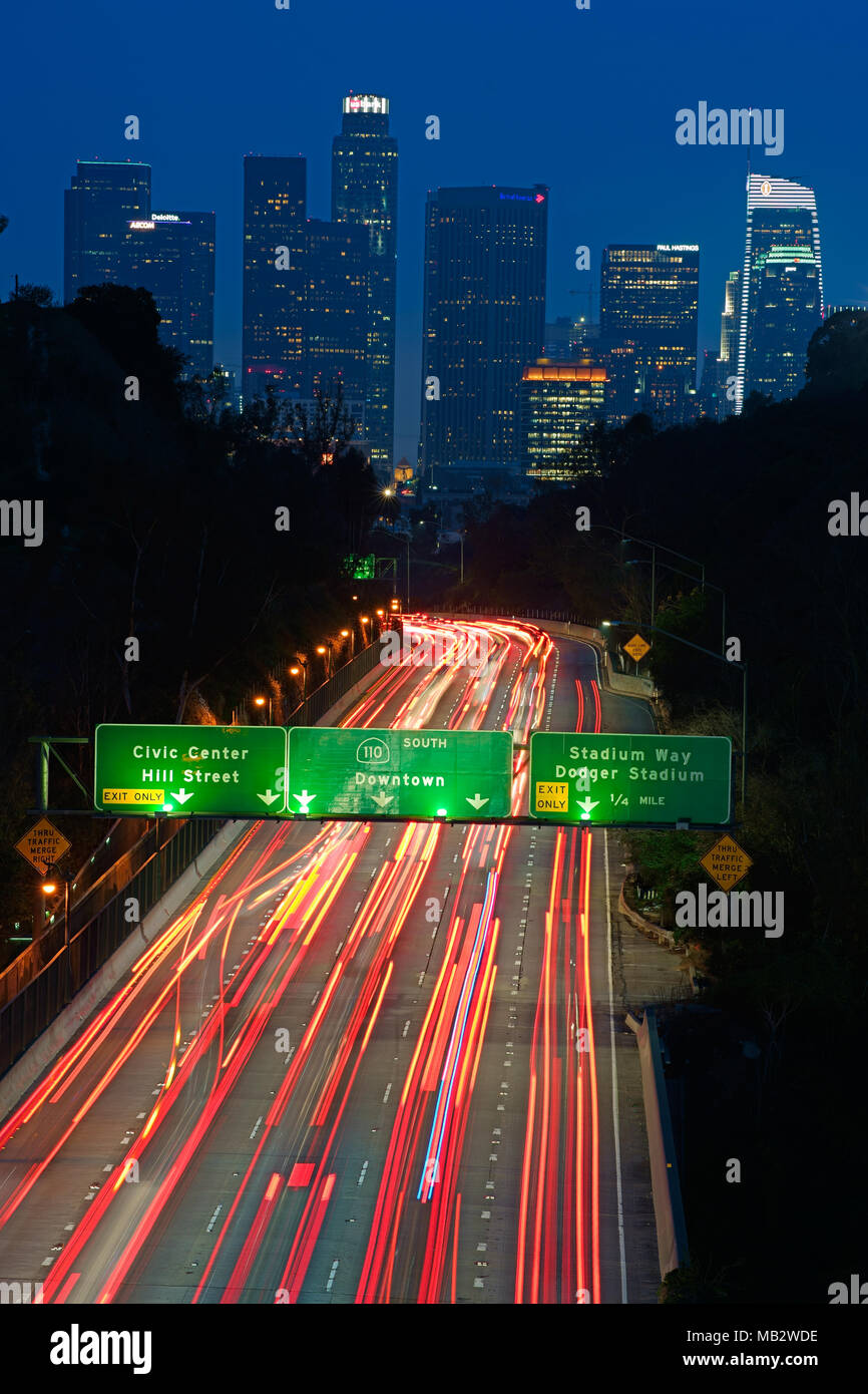 Light trails on the Arroyo Seco Parkway with Downtown Los Angeles in the distance. Los Angeles County, California, USA. Stock Photo
