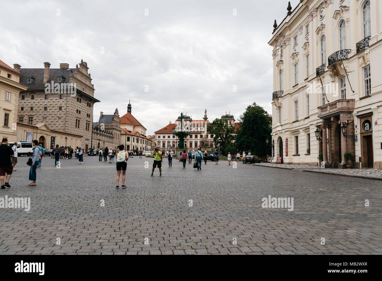 Prague,  Czech Republic - August 19, 2017: Tourists in Hradcany Square a cloudy day. It is located near Prague Castle and archdiocese building Stock Photo