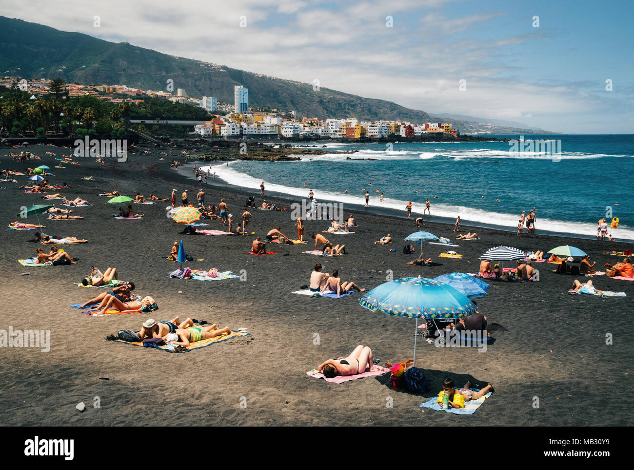 Puerto de la cruz, Tenerife, Canary islands, Spain - May 30, 2017: People sunbathing and relaxation in Playa Jardin. One of the best black sand beache Stock Photo