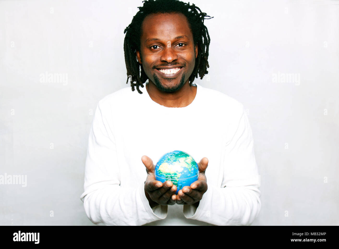 A smiling young man holds the world globe in his hands Stock Photo - Alamy