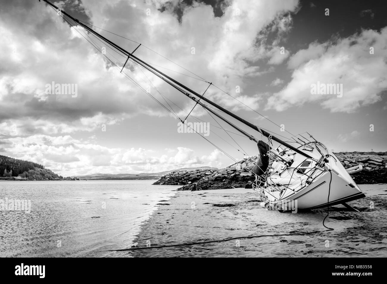 A Black and white photo of a sail boat out of water at low tide. Stock Photo