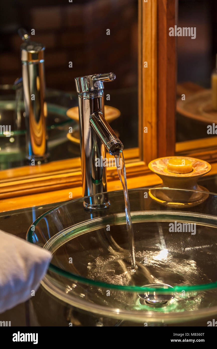 Tap flowing in a luxurious hotel room bathroom Stock Photo