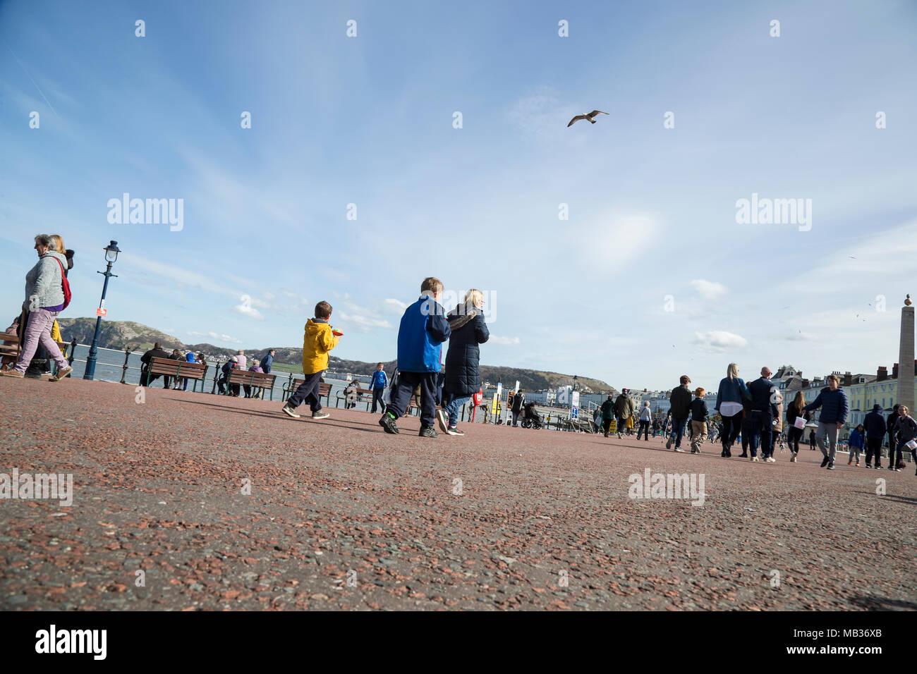 Holiday makers enjoying a sunny day on a seaside promenade at Llandudno north shore in Wales Stock Photo