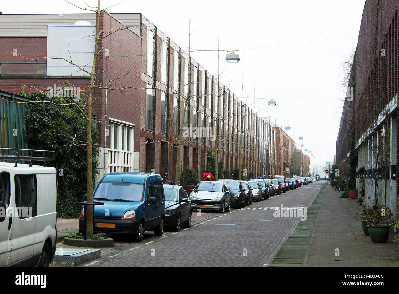 Quiet street of a small north european town. Cars are parked in the side of driveway. Stock Photo