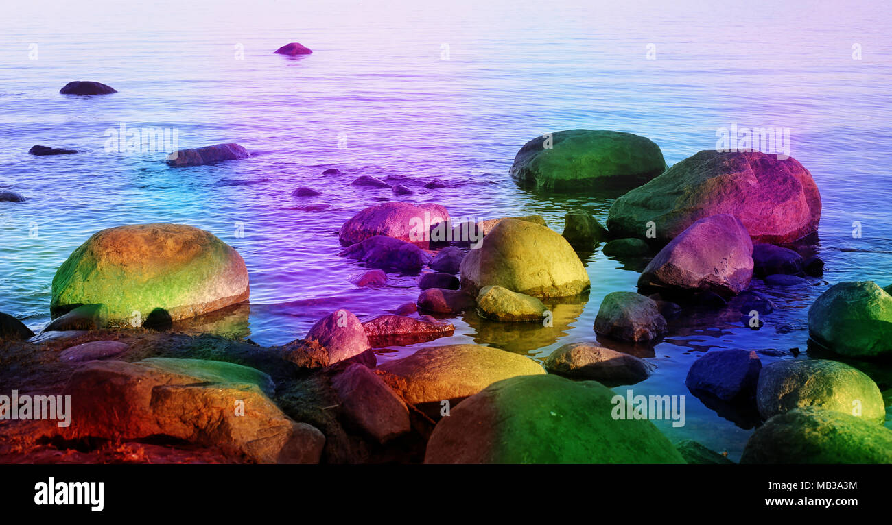 Fantasy themed landscape including colorful rocks in the sea. Calm sea and beautiful colors of the rocks create a fairytale-like magical atmosphere. Stock Photo