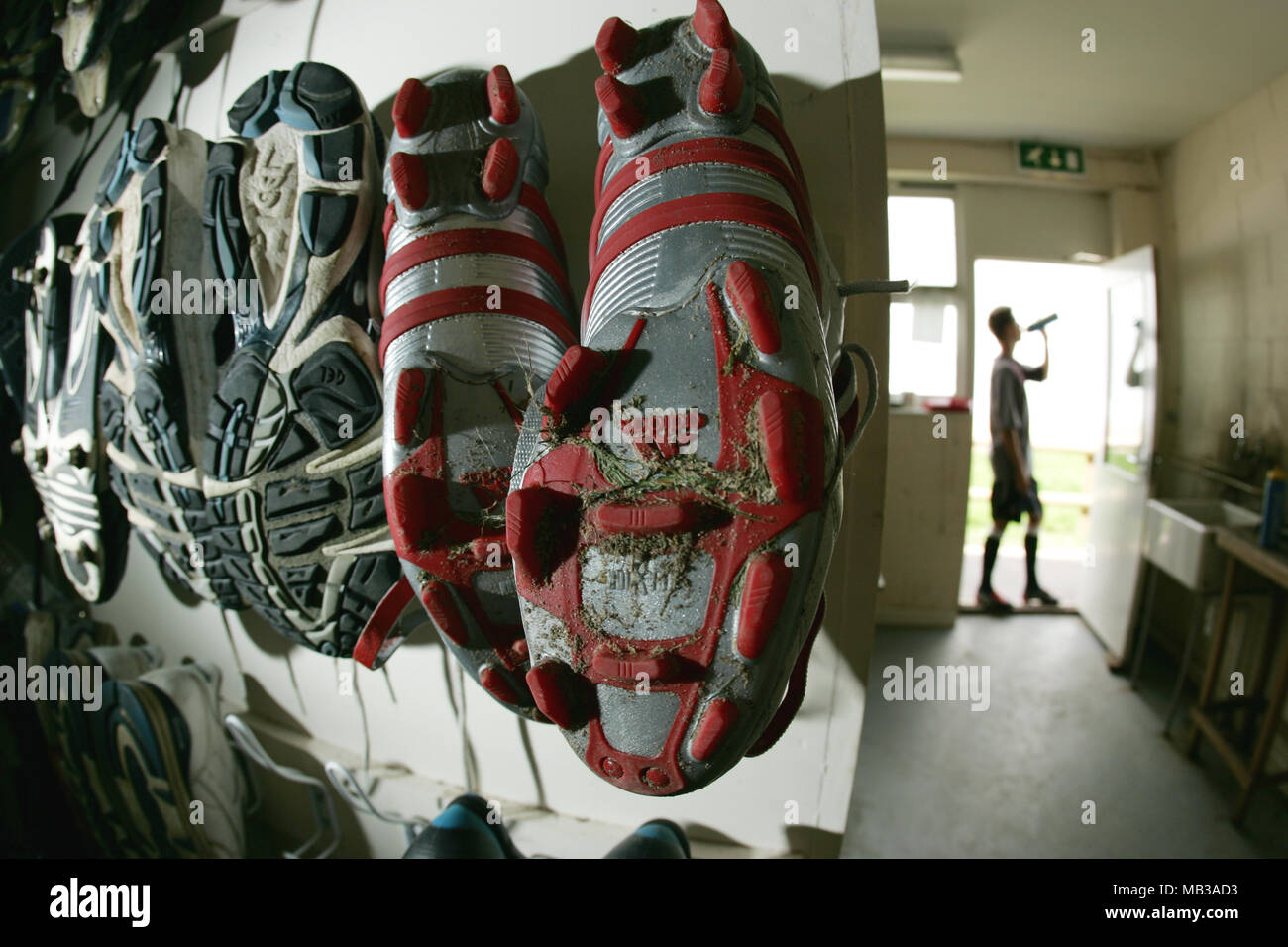 Red and silver Adidas football boots showing tread pattern from the 2004-6  era hung up on hooks in a changing room Stock Photo - Alamy