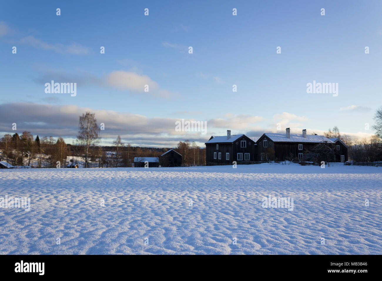 Old - traditional - houses in rural sweden on a beautiful winters day, with blue sky and calm clouds. Stock Photo