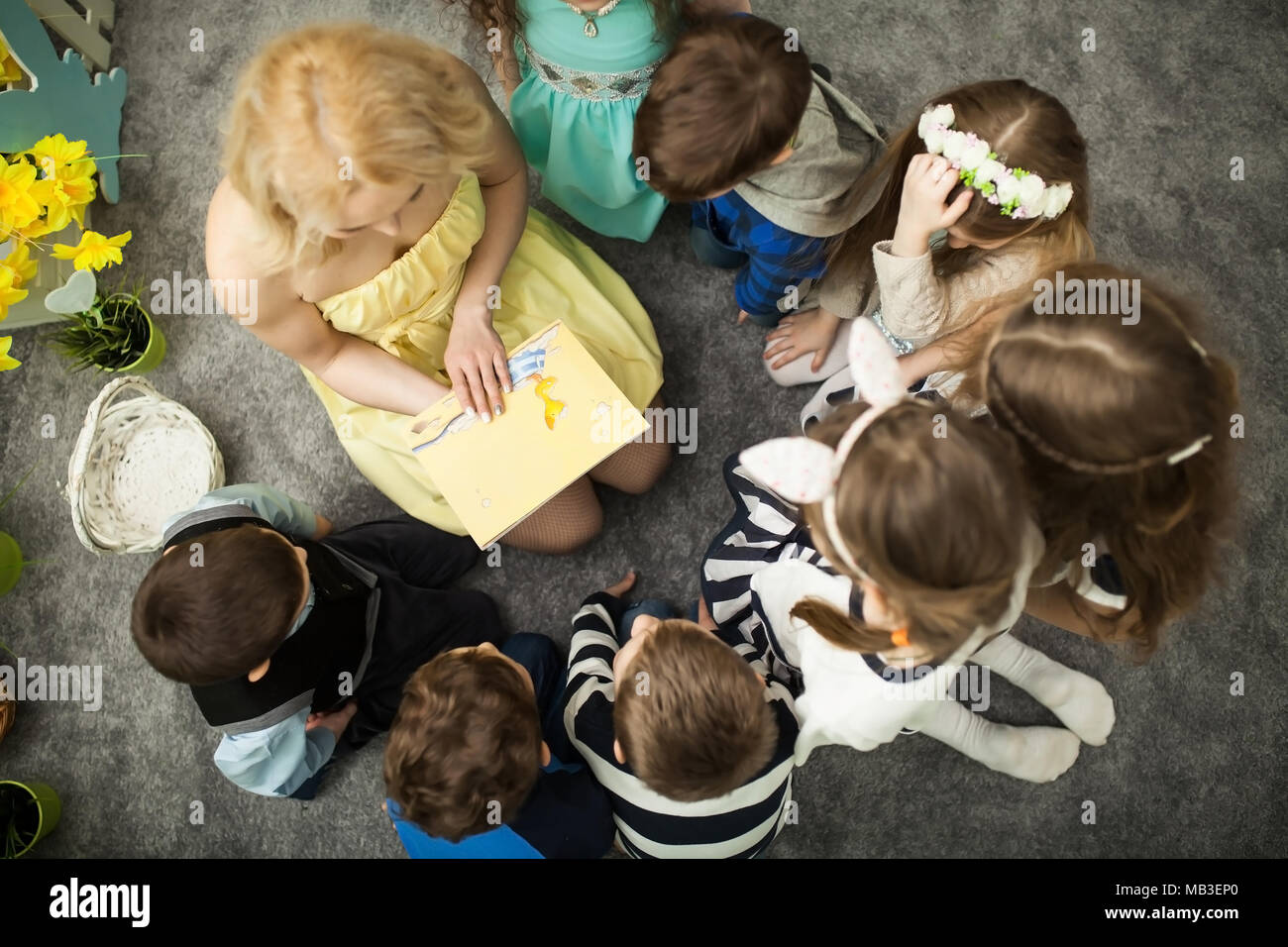 The teacher is reading a book to children stock photo alamy