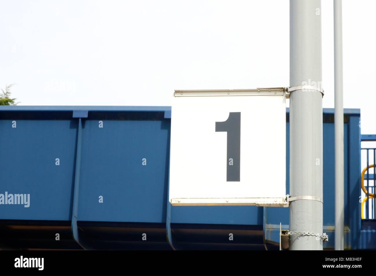 Platform 1 sign at a railway station in front of bridge Stock Photo