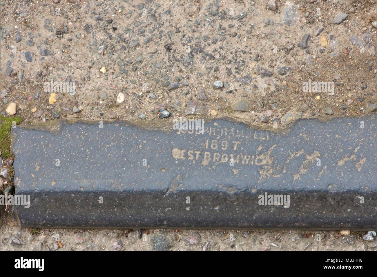 Old kerb stone in road with 'Joseph - 1897 West Bromwich' inscribed on it at Deddington, Oxfordshire, UK Stock Photo