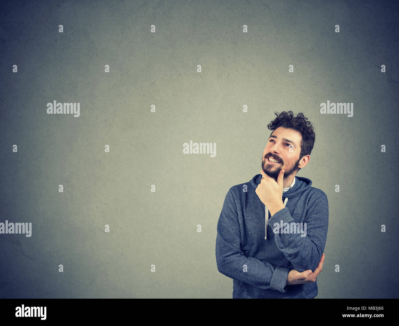 Portrait side profile man thinking looking up isolated on gray wall background with copy space. Human emotions, perception Stock Photo
