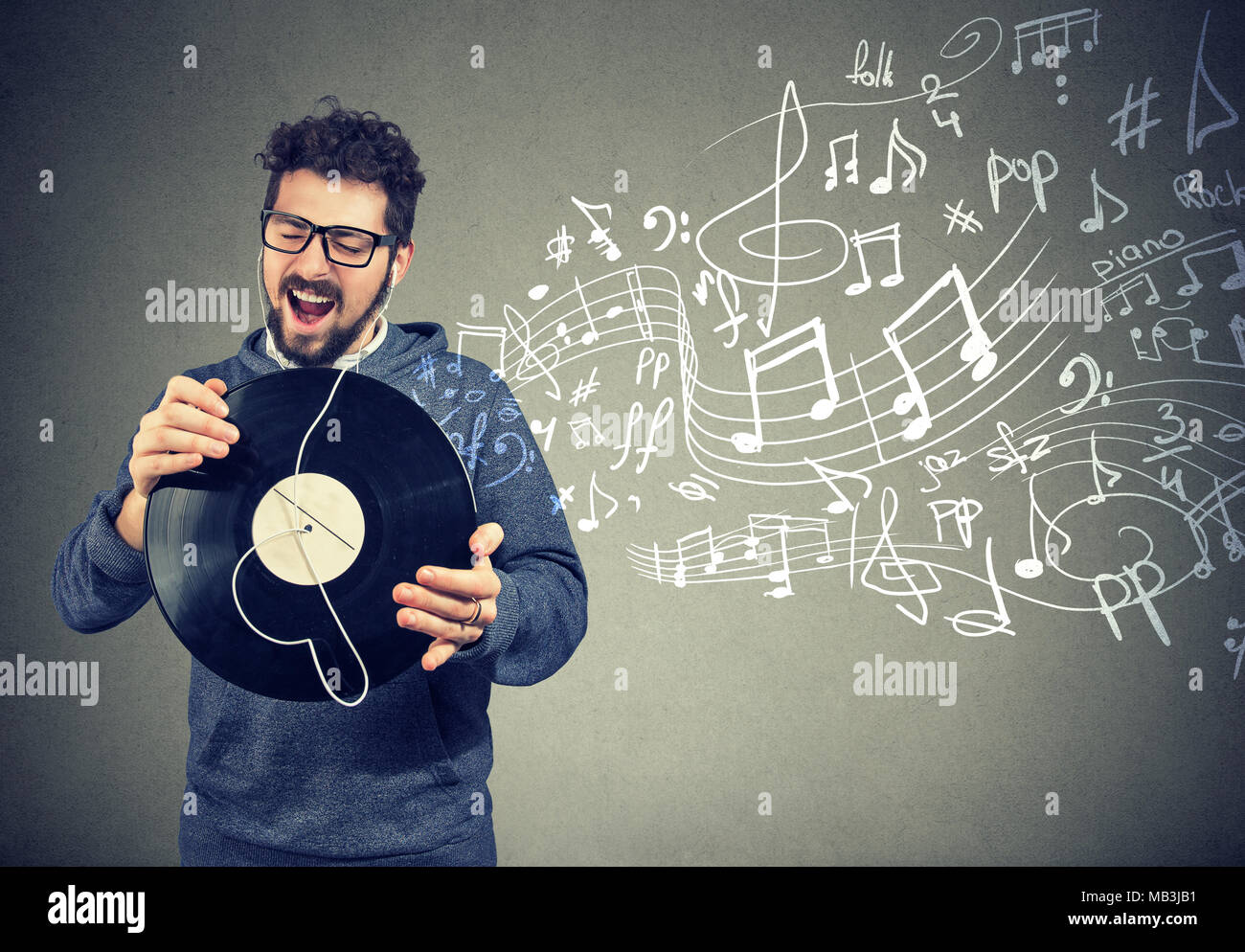 happy casual man with vinyl record disc listening to music singing Stock Photo