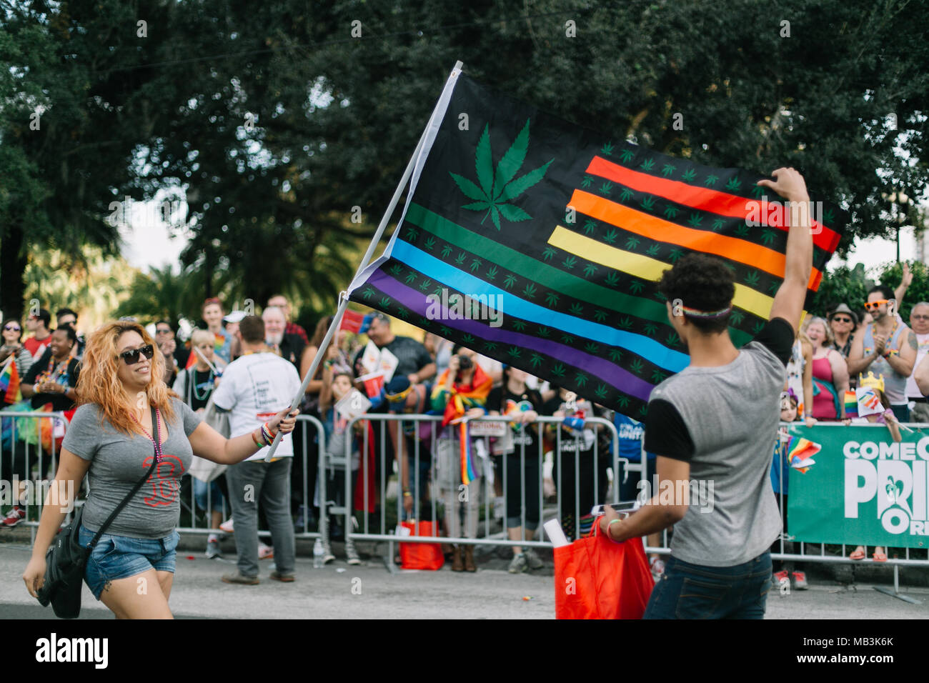 Two people hold Marijuana flag pride flag at Orlando Pride Parade (2016). Stock Photo