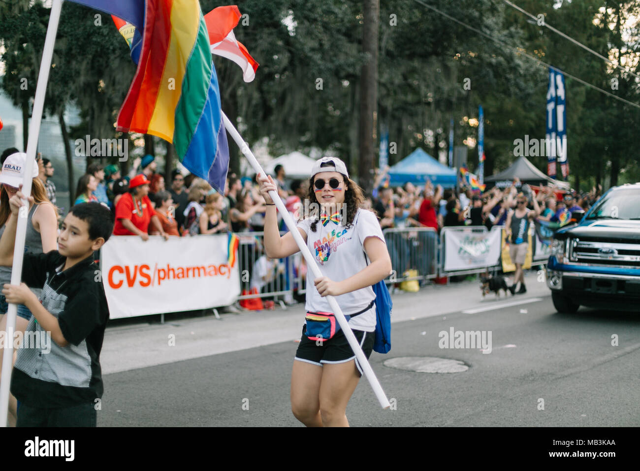 Person wearing 'Make American Gay Again' T-Shirt and holding rainbow flag at Orlando Pride Parade (2016). Stock Photo