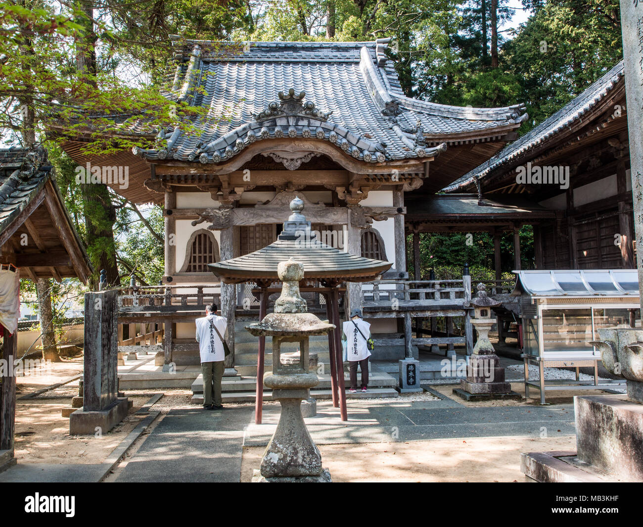 Two henro pilgrims worship in front of the Daishi hall at Butsumokuji, Temple 42 of  the 88 Temple Shikoku Pilgrimage. Stock Photo
