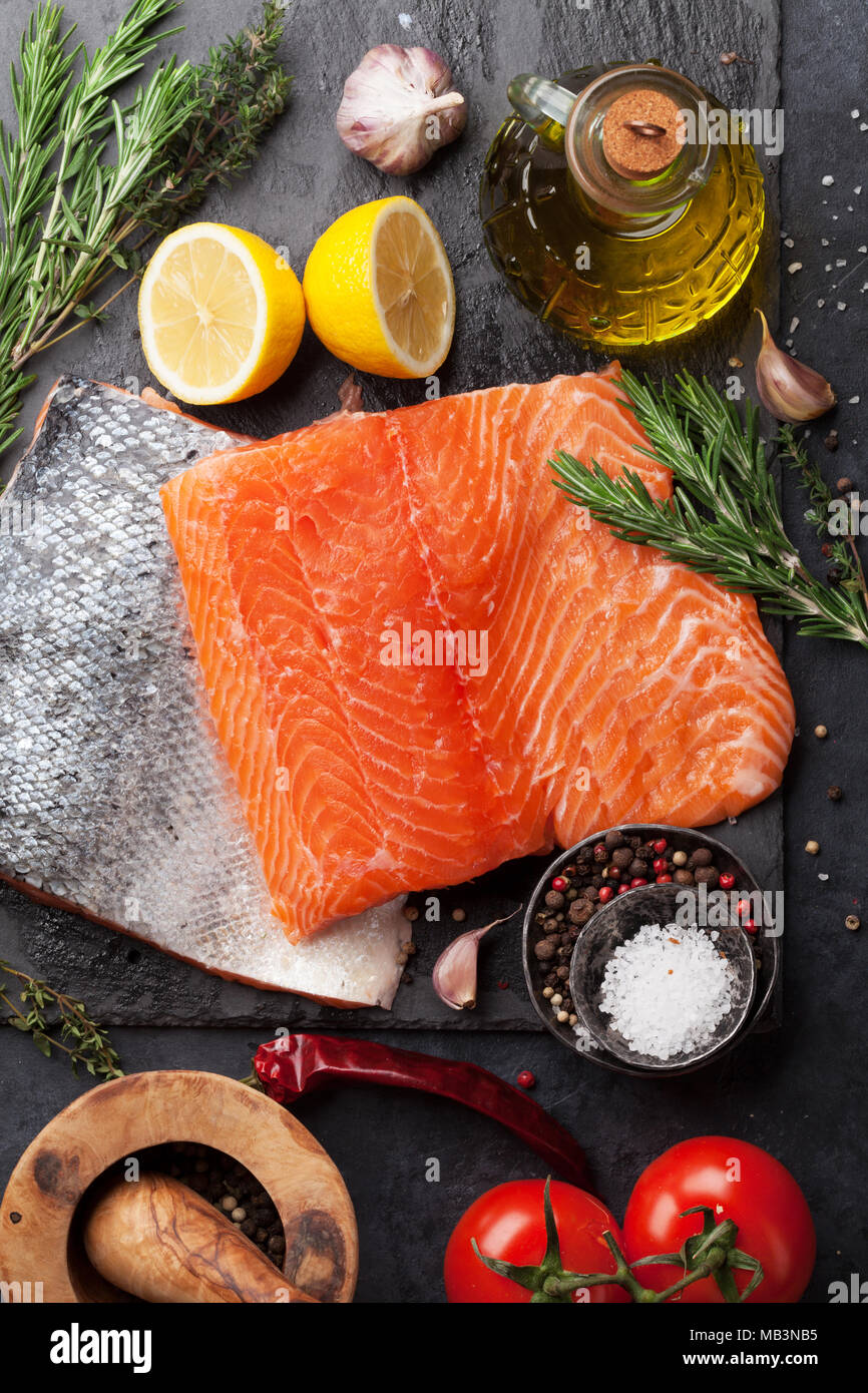 Raw salmon fish fillet with spices cooking on cutting board. Top view ...