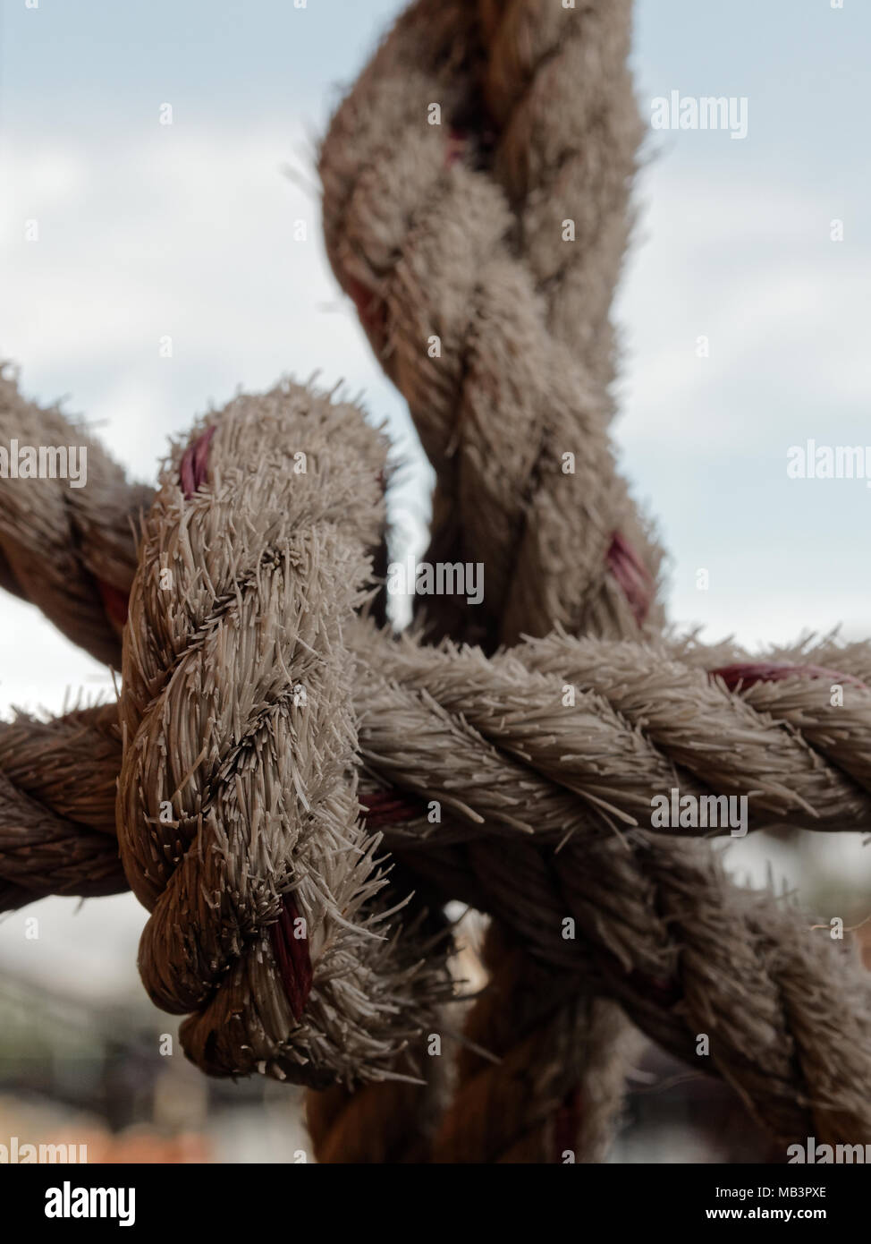 Hemp rope tied together on steel raft in net shape to prevent someone falling into water over rural area background Stock Photo