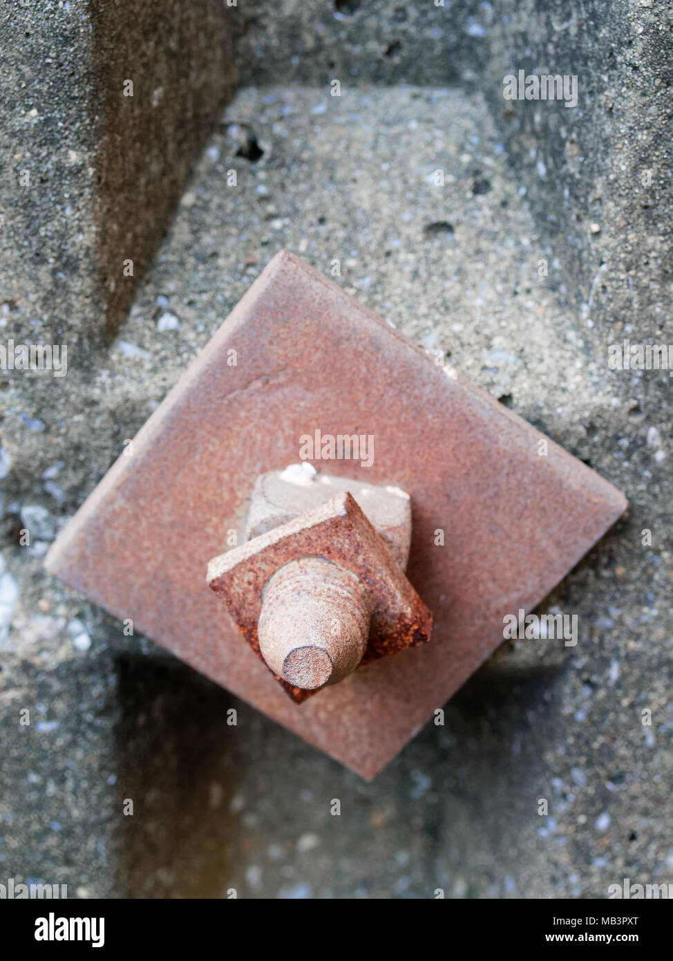 Old rustic metal bolt, nut, and washer on concrete electric pole in grunge, vintage, or retro style show concepts of strength, connection, and heavy industry Stock Photo