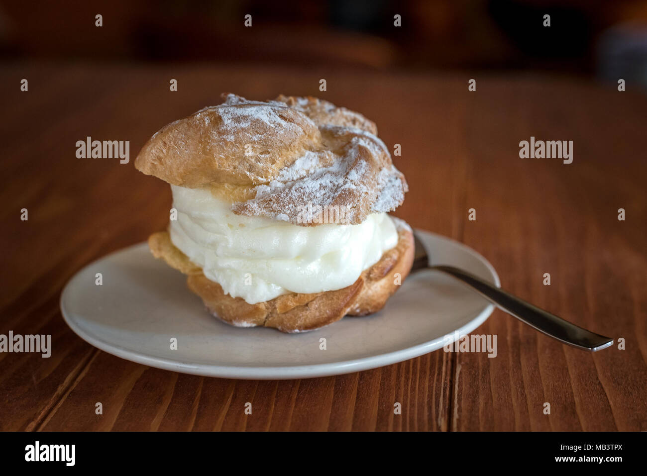 Close up of a princess donuts with a spoon on a plate, on a wooden table, Selective focus Stock Photo