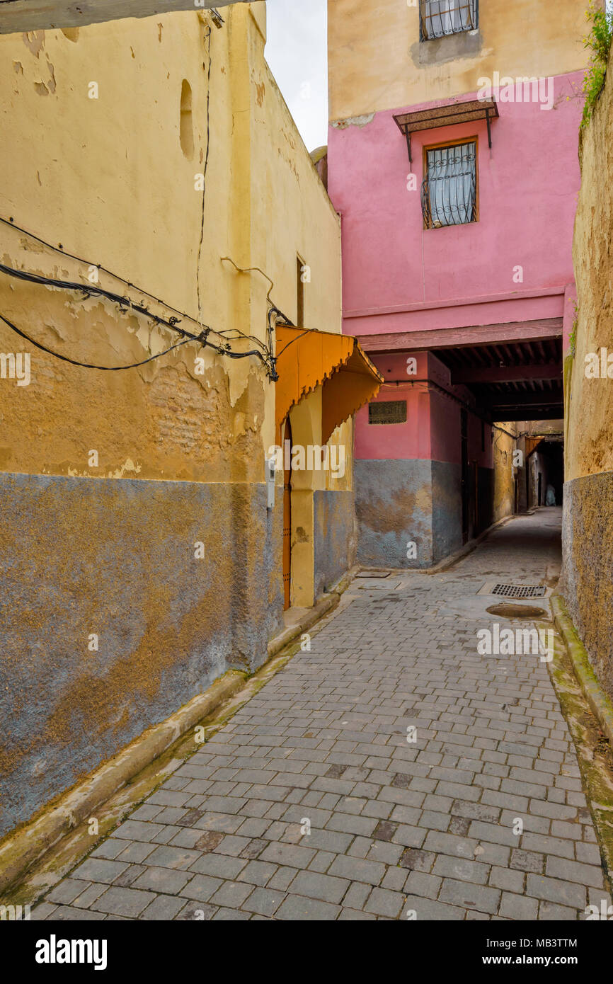 MOROCCO FES MEDINA SOUK NARROW ALLEYWAY WITH YELLOW AND PINK WALLS Stock Photo