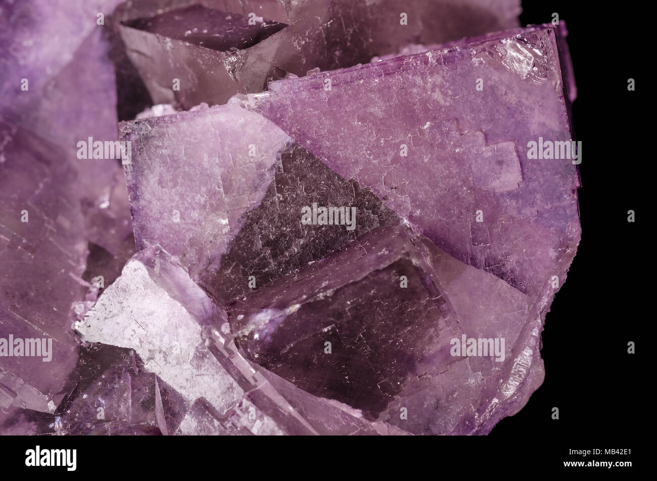 Surface of a fluorite crystal cluster. Fluorspar, mineral form of calcium fluoride, CaF2. Halite mineral. Colorful pink and purple cubic crystals. Stock Photo