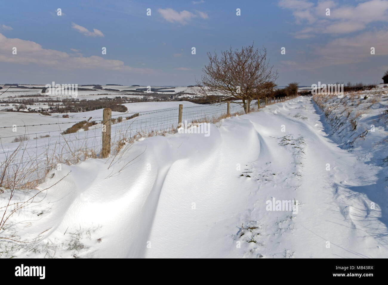 Snowdrifts on a footpath on Langford Down, overlooking the Wylye Valley in Wiltshire. Stock Photo