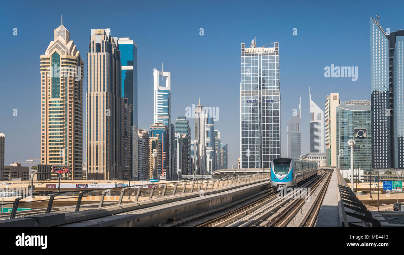 A Dubai Metro train  and downtown office towers in Dujbai, UAE, Middle East. Stock Photo