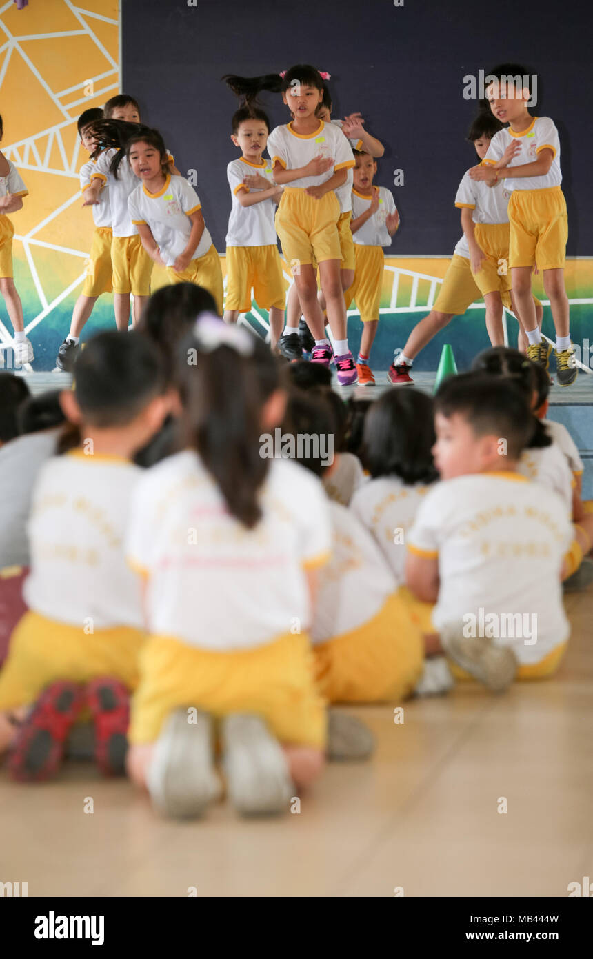 Children are enjoying themself when their friends performing on stage at their kindergarten sport day. Stock Photo