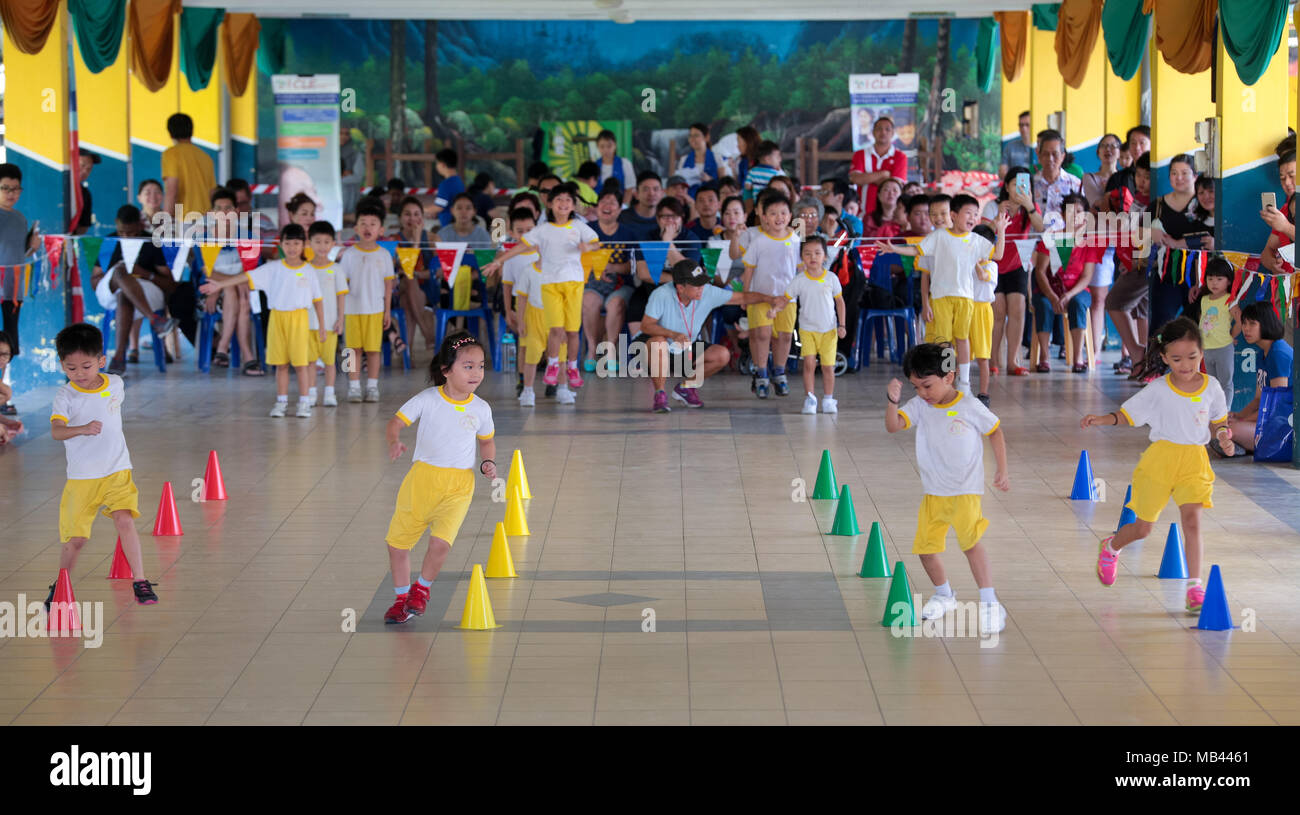 Children are competing in a zig zag race at their kindergarten sport
