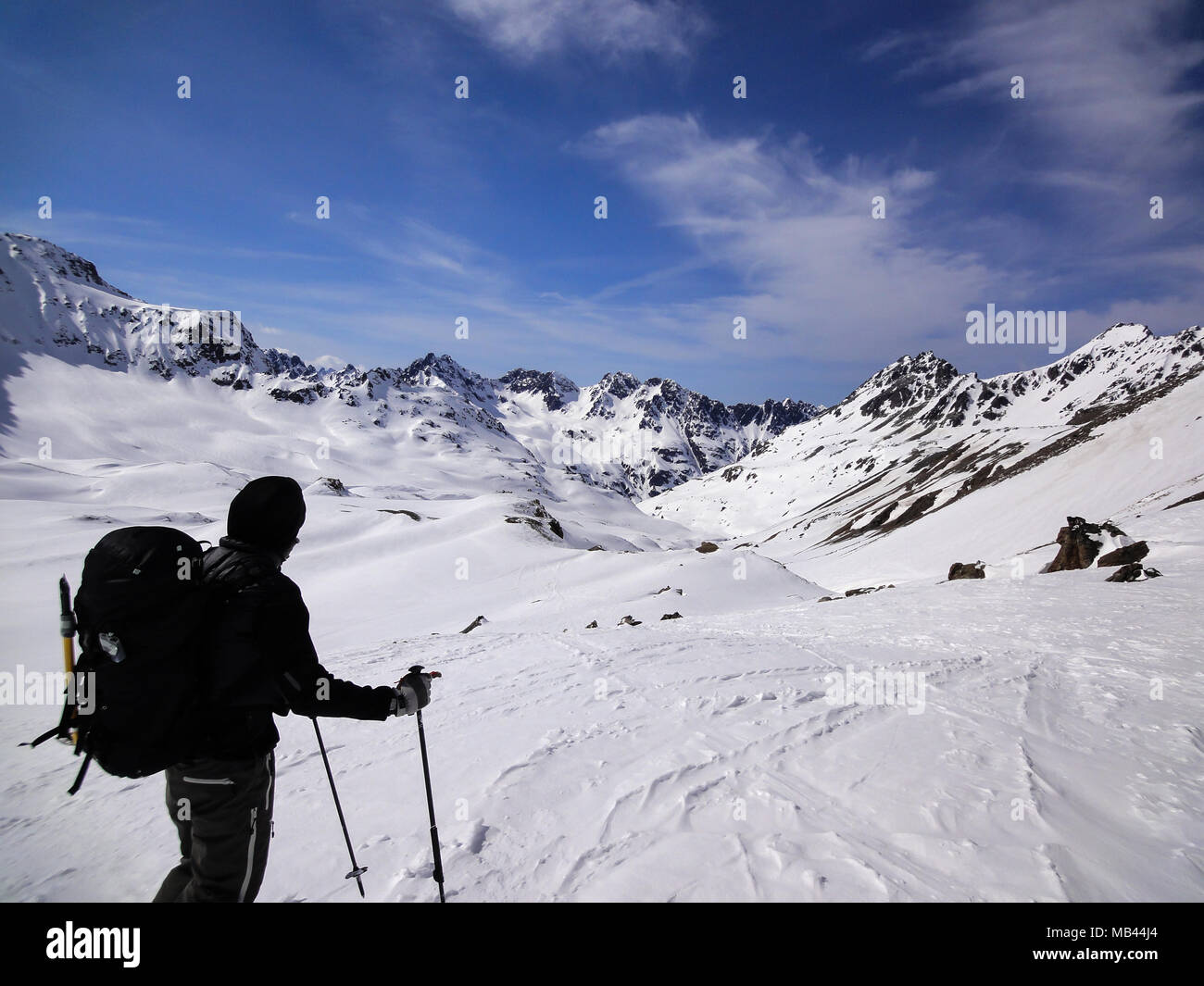 male backcountry skier looks at mountain landscape and his goal for the day's backcountry ski tour Stock Photo