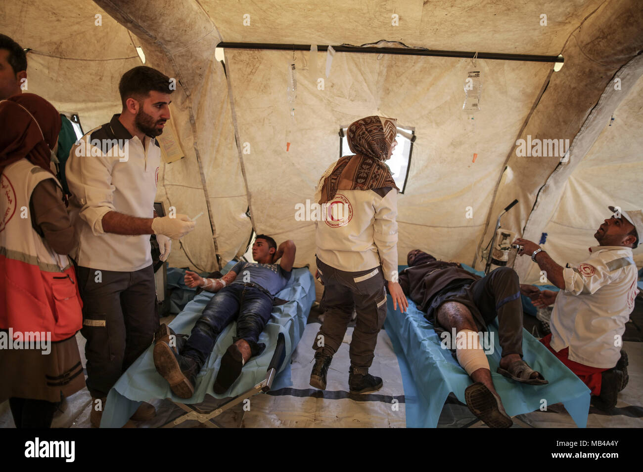 Jabalia, Gaza Strip. 06th Apr, 2018. Injured Palestinian protestors receive treatment at a medical tent during clashes with Israeli Security Forces along the Israel-Gaza border in Jabalia, Gaza Strip, 06 April 2018. Thousands of Palestinians are marching to the border area for the second week of a six-week long protest dubbed the 'Great March of Return' along the Gaza-Israel border. The march is to highlight the hundreds of thousands of Palestinian refugees who were expelled or fled their homes during the 1948 war that marked Israel's creation. Credit: Wissam Nassar/dpa/Alamy Live News Stock Photo
