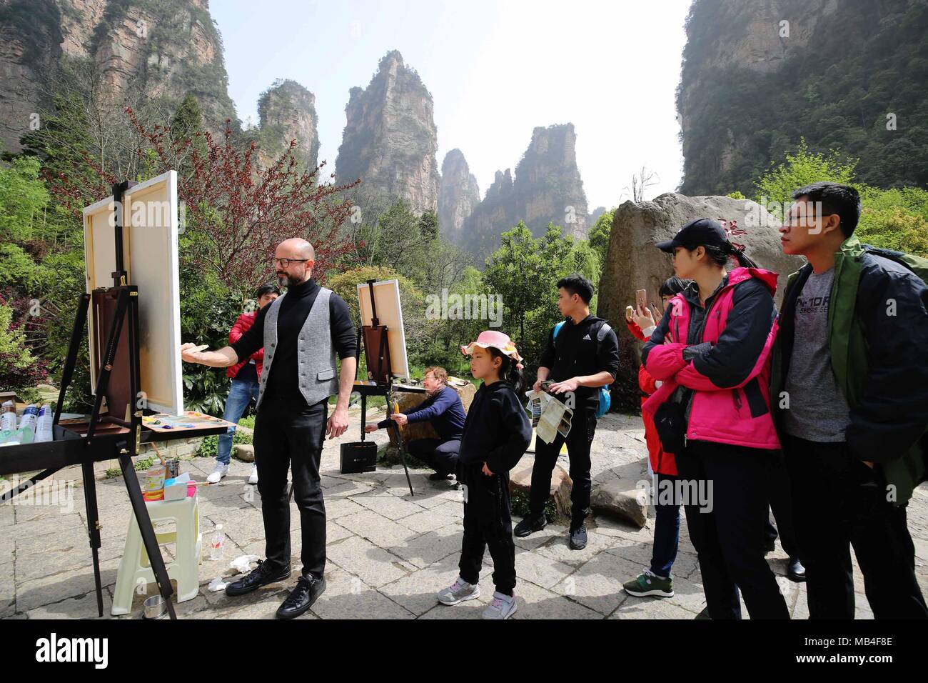 Zhangjiajie, China's Hunan Province. 6th Apr, 2018. Giorgio Distefano (1st L) from Italy paints at Zhangjiajie UNESCO Global Geopark at Wulingyuan District of Zhangjiajie City, central China's Hunan Province, April 6, 2018. About 21 artists coming from Italy took part in a cultural event at the geopark which is known for its quartzose sandstone landform. This geopark is one of the geoparks in China that have already been chosen by UNESCO on its World Network of Geoparks. Credit: Wu Yongbing/Xinhua/Alamy Live News Stock Photo
