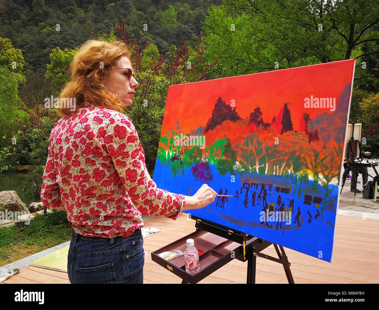 Zhangjiajie, China's Hunan Province. 6th Apr, 2018. Julienna Polidoro from Italy paints at Zhangjiajie UNESCO Global Geopark at Wulingyuan District of Zhangjiajie City, central China's Hunan Province, April 6, 2018. About 21 artists coming from Italy took part in a cultural event at the geopark which is known for its quartzose sandstone landform. This geopark is one of the geoparks in China that have already been chosen by UNESCO on its World Network of Geoparks. Credit: Wang Jianjun/Xinhua/Alamy Live News Stock Photo